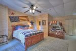 Lower level bedroom with a queen bed, set of bunk beds and a kids tent 